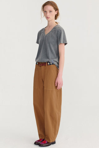 Woman wearing grey t-shirt and brown loose fitting pants. 