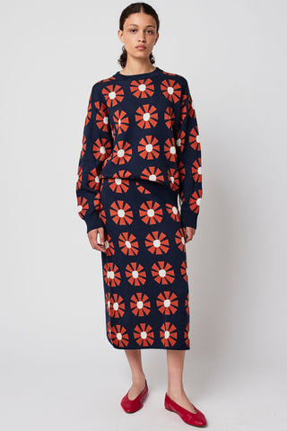 Woman wearing retro geometric floral print knit skirt and matching sweater by Bobo Choses. 