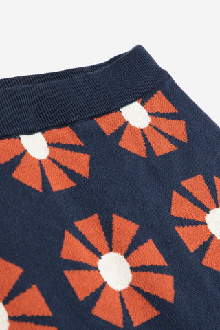 Close-up flat lay photo of navy and red retro geometric floral pattern knit skirt's waistband by Bobo Choses. 