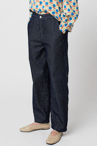 Close-up of woman wearing navy and white pinstripe organic cotton relaxed fit jeans by Bobo Choses. 