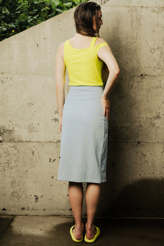 Woman wearing yellow top and washed denim Palma pencil skirt. 