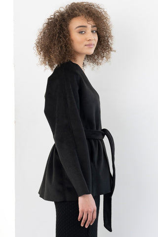Model wearing black open front belted Malcolm cardigan / jacket by Bodybag. 