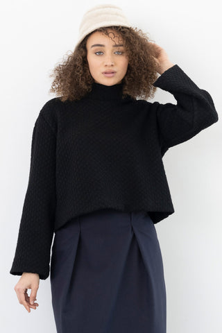 Model wearing black coloured textured bell sleeve Waters top by Bodybag. 