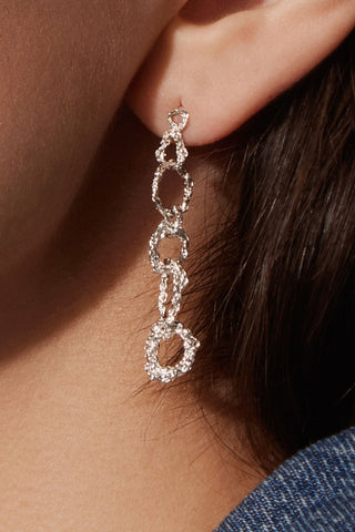 Close-up of ear with sterling silver chunky chain drop earrings by Camillette. 