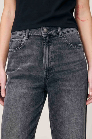Close-up of woman's waist wearing black faded straight leg Karmine jeans by DL1961. 