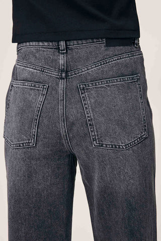 Close-up of back of woman's waist wearing black faded straight leg Karmine jeans by DL1961. 
