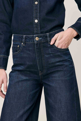 Close-up of waist band of model wearing Ventura dark wash high rise barrel leg Miro Jeans by DL1961. 