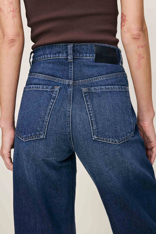 Back view close-up of model wearing a relaxed fit barrel leg Taylor jeans by DL1961. 