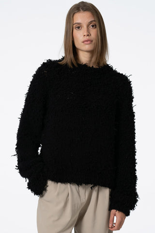 Model wearing black hand knit zero waste cashmere sweater by Dinadi.