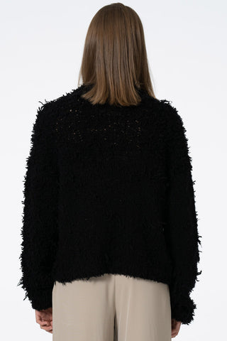Back view of model wearing black hand knit zero waste cashmere sweater by Dinadi.