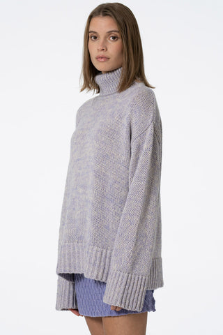 Side view of model wearing lilac oversized Merino Turtleneck sweater by Dinadi. 