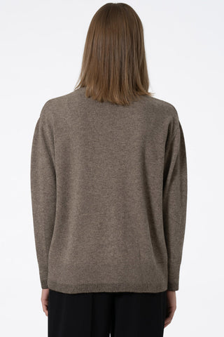 Back view of model wearing oat brown Yak wool round neck sweater by Dinadi. 