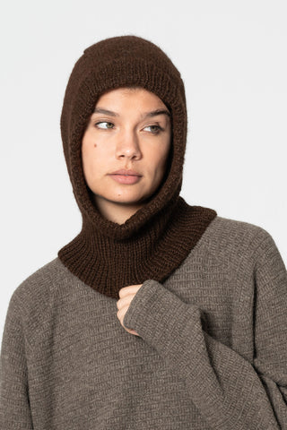 Woman in front of white background wearing light brown knit sweater and brown knit Alpaca wool Balaclava by Dinadi. 