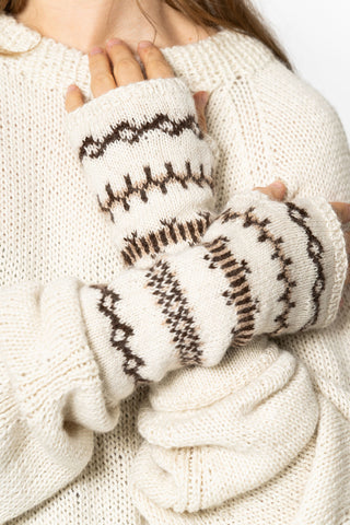Close-up of woman wearing ivory sweater and ivory & brown fingerless Alpaca Wool gloves by Dinadi. 
