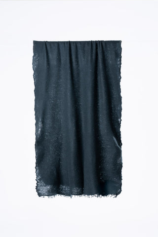 Teal blue green felted cashmere scarf folded in half in front of grey background. 