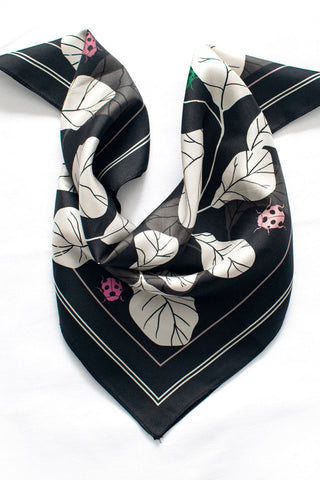 Black and white silk twill scarf folded on white background. 