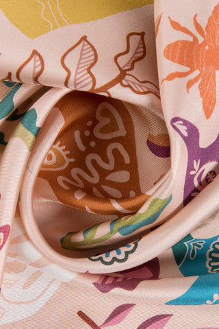 Close-up of pink twill silk scarf with multicolour print. 