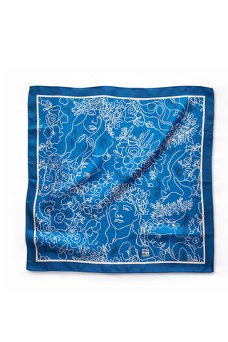 Blue silk scarf with white line drawings of women's faces and flowers. 