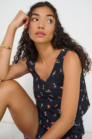 Woman wearing black cropped tank top with colourful surfer print. 