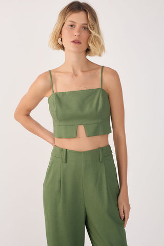 Woman wearing green cropped tank top with spaghetti shoulder straps and green matching pants. 