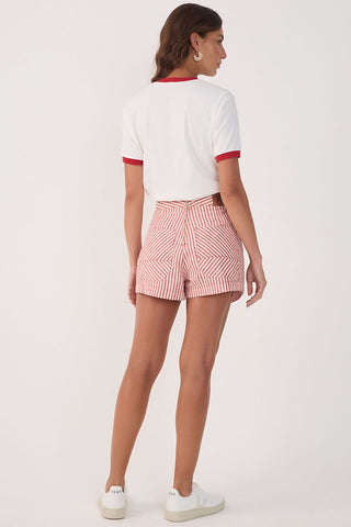 Back view of woman wearing white t-shirt with red trim with red and white stripe asymmetrical front short. 