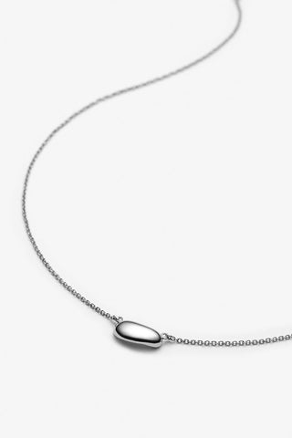 Silver necklace with pebble pendant on white background. 