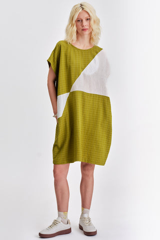 Woman in front of  white background wearing green and white colour blocked relaxed fit tunic. 