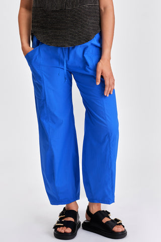 Woman wearing black stripe tanktop, blue pants and black sandals. 