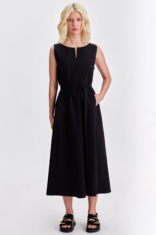 Woman wearing black sleeveless belted midi dress with black sandals. 