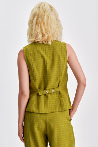 Back view of woman wearing olive green button vest with matching pants. 