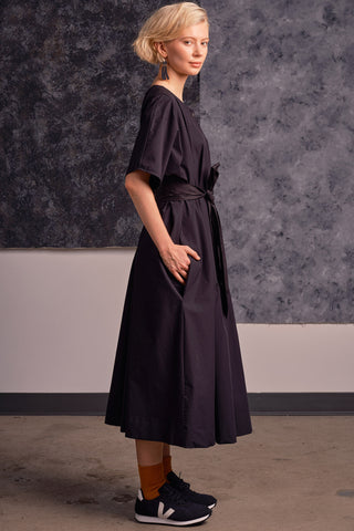Side view of model wearing black coloured OEKO-TEK belted Adira Shift Dress by Jennifer Glasgow. 