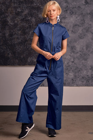 Model wearing flight blue organic cotton zip up Anath jumpsuit by Jennifer Glasgow. 