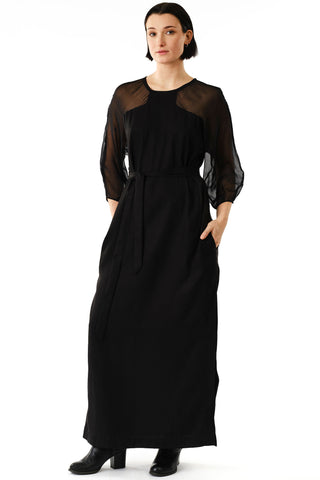 Woman in front of white background wearing black full length Betana Dress by Jennifer Glasgow. 