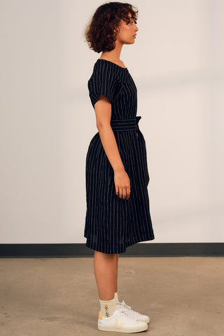 Side view of woman wearing oversized linen black and white stripe Camilla dress with Jennifer Glasgow. 
