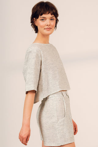 Side view of woman wearing boxy linen blend grid print Cardera Top by Jennifer Glasgow. 