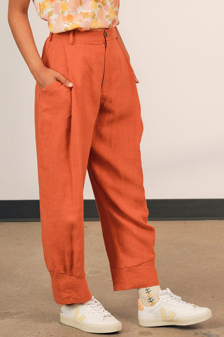 Closeup of woman wearing pumpkin orange linen Ceres pants by Jennifer Glasgow. 