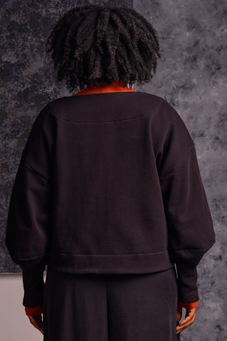Back view of model wearing black OEKO-TEK tencel organic cotton blend Clyde Sweater by Jennifer Glasgow. 