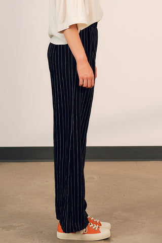Side view of woman wearing black stripe linen Diane Pants by Jennifer Glasgow. 