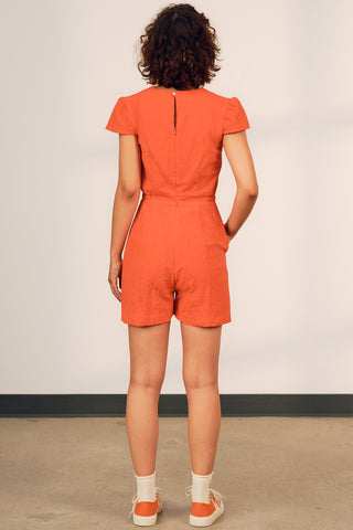 Back view of model wearing a coral red crinkle cotton short Eula romper by Jennnifer Glasgow. 