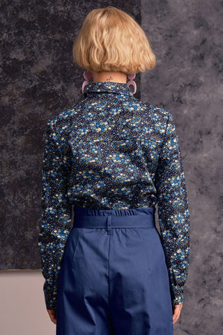 Back view of model wearing blue floral print Fianna button up shirt by Jennifer Glasgow. 