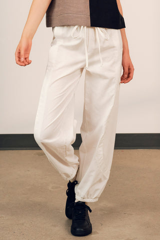 Closeup of model wearing white cotton track inspired Finnely Pants by Jennifer Glasgow. 