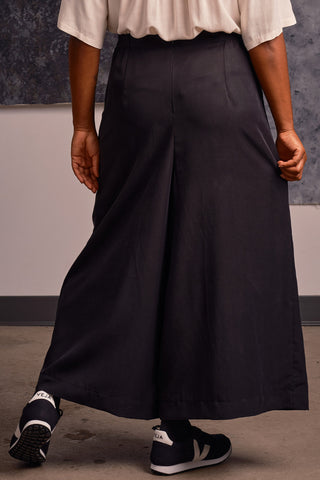 Back view of model wearing navy black OEKO-TEK Tencel wide leg pleated Harlow pants by Jennifer Glasgow. 