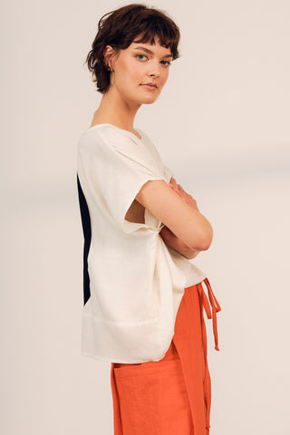 Side view of woman wearing cream and black colour blocked Iris top by Jennifer Glasgow. 