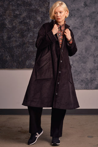 Model wearing black corduroy A-line Joan coat by Jennifer Glasgow. 