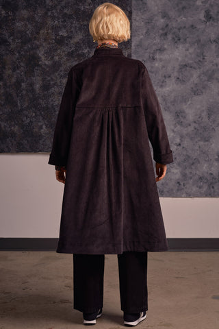 Back view of model wearing black corduroy A-line Joan coat by Jennifer Glasgow. 