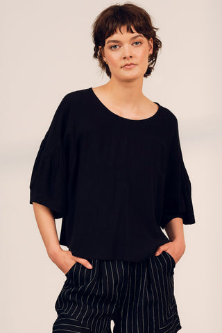 Model wearing black oversized Kairi Top by Jennifer Glasgow. 