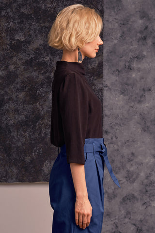 Side view of model wearing black mock neck 3/4 length sleeve Maeve top by Jennifer Glasgow. 