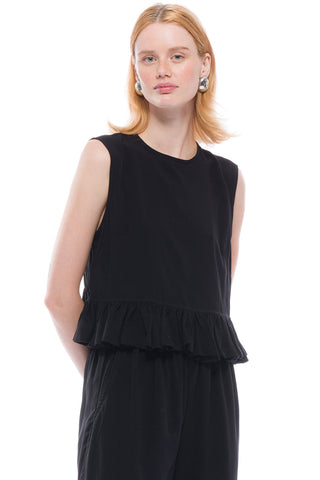 Woman wearing black rayon Matille ruffle top by Toit Volante. 