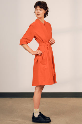 Model wearing coral red button up belted Orlop dress by Jennifer Glasgow. 