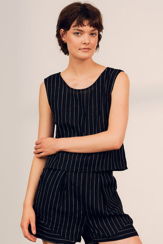 Woman wearing a linen black and white strip Tenaya top by Jennifer Glasgow. 